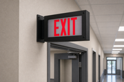 Black finish high-abuse LED exit sign side-mounted beside a commercial doorway